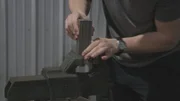 Ein Mann legt Eisenteile in einen Schraubstock