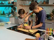 Vasko und Enes testen Ananas-Schneidetechniken.