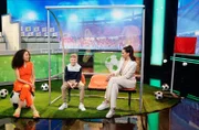 Fragekind Rudi (M) sitzt zwischen Siham El-Maimouni (l) und Esther Sedlaczek (r) und will wissen, welche Strecke ein Fußball in einem Bundesligaspiel insgesamt zurücklegt.