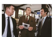 Barnaby (John Nettles, l.) und sein Assistent Jones (Jason Hughes, r.) zeigen Heimatmuseumsdirektor Giles Cato (Michael Elwyn, M.) eine Grusel-Broschüre über Spukhäuser in Midsomer.