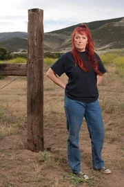 Tia Maria Torres stands on ranch land across the driveway from Villalobos Rescue Center