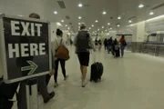 Passengers exit baggage claim area after arrival. (National Geographic/Lucky 8 TV)