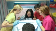 Jenny giving birth with George, nurses and Dr. Neil in the ER.