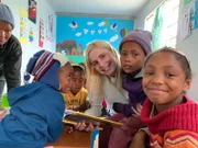 Ausflug und Besuch der Reiseleiter Bernd (nicht im Bild) und Caro zusammen mit Bordseelsorger Stefan Hippler ins Township Hope Capetown in Südafrika. Die beiden lernen die Kinder im Kindergarten kennen, spielen und malen mit ihnen.