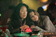In der Bar fordert Meredith (Ellen Pompeo, r.) Cristina (Sandra Oh, l.) zu einem Spiel von "wessen Leben ist am schrecklichsten" heraus. Gerade, als Cristina die Trumpfkarte spielt, kollabiert Joe, der Barbesitzer ...