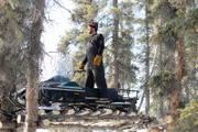 Johnny Rolfe hebt sein Schneemobil vom Boden ab, um sich von Bären fernzuhalten. (National Geographic/Mike Fennell)