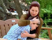 Genau auf dieser Parkbank hat sein Freund zu Lebzeiten gesessen. Lily Lebowski (Kathryn Hahn) tröstet den kleinen Johnny (Soren Fulton).