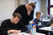Jonas Jäger (34) hilft einem Schüler während des Unterrichts an der Heinrich-Hübsch-Berufsschule in Karlsruhe.