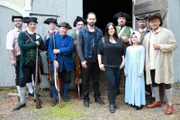 Hosts Nick Groff and Katrina Weidman stand with actors in Revolutionary War re-enactment wardrobe.