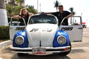 Entertainerin Kiona und Kreuzfahrtdirektor Thomas Gleiß posieren an einem alten VW Käfer in Acapulco, Mexiko.