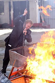 Horatio (David Caruso) versucht den brennenden Mann, der offensichtlich auf einem Haufen von Schrott und Reifen mit Benzin übergossen und angezündet wurde, zu retten...