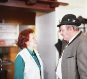 Kriminalkommissar Veigl (Gustl Bayrhammer) mit seiner Schwester Rosl (Erika Blumberger), die Gastwirtin in einem Gasthaus am Ammersee ist.