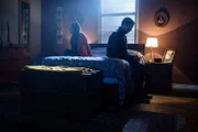 Frau und Mann sitzen auf einem Bett