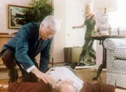 Nadine (Kelly Mullis, r.) sieht entsetzt, wie ein ihr Unbekannter - Dr. Sloan (Dick Van Dyke, l.) - sich über die Leiche ihres Chefs beugt.