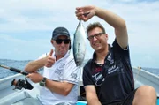 Stellvertretender Kreuzfahrtdirektor Jörn Hofer und Kapitän Morten Hansen posieren mit einem gefangenen Fisch