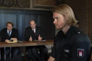 Lars Meckel (Matthias Ziesing, l.) und Markus Gellert (Herbert Knaup, M.) warten gespannt auf die Aussage von Polizist Burghard Menke (Lennart Lemster, r.) vor Gericht.