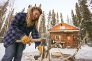 Ray's wife chopping wood with an axe.