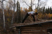 Ray working on the roof of the log cabin.