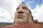Das Gesicht des Crazy Horse Memorials hebt sich deutlich vom bewölkten Himmel ab.