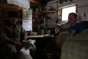 The Seldens in their cabin with two dogs.
