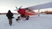 Bob with Ruggar on a leash next to an airplane.