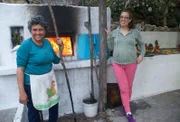 Tsabika (li). und Mersina Polichroni vor ihrem Holzbackofen