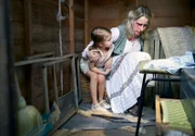 Die verletzte Carol Alexander (Zoe Harrison, r.) versteckt sich mit ihrer Tochter Nikki (Maddy Collins, l.) im Gartenschuppen.