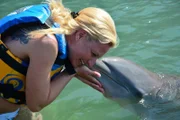 Passagierin Iris geht in St. Kitts in der Karibik auf Tuchfühlung mit einem Delfin.