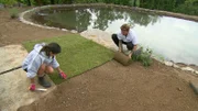 Familie Stahl verlegt den Rollrasen um ihren neuen Schwimmteich.