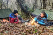 L-R: Cynthia Erivo und Bear Grylls sprechen über ihre Lebenserfahrungen am Feuer während ihres Abenteuers in Brecon Beacons, Wales.