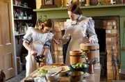 Kochen wir früher: Charity (Jacqueline Nairn, l.) mit Evie (Violet O'Halloran).