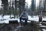 Heimo warms up by the camp fire.