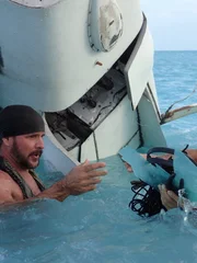 L-R: Joe Teti und Matt Graham im Wasser mit Teilen aus dem Flugzeug.