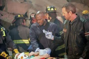 Dr. Foreman (Omar Epps, M.) und Dr. House (Hugh Laurie) kümmern sich um die vielen Schwerverletzten, die unter den Trümmern eines eingestürzten Hauses liegen.