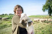 Anja Wolff von den Jakobsberger MilchHandwerkern in Jakobsberg hat ein Lamm ihrer Milchschafe auf dem Arm.