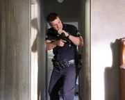 Officer John Nolan (Nathan Fillion) durchsucht akribisch ein leerstehendes Haus nach Verdächtigen.
