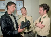 Kommissar Bonhoff (Wolfgang Krewe, li.) zeigt den beiden Polizisten (re. Maximilian Held, 2.v.re. Jan Andres) einen Schuh, wie er von Streifenpolizisten getragen wird und dessen Abdruck in der Wohnung des Opfers gefunden wurde...