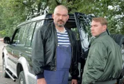 Die Kampfhundehalter Peter Bock (Gennadi Vengerov, li.) und Fredy Lehmann (Thomas Arnold) sind über den Besuch der Polizei nicht sonderlich begeistert.