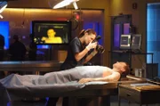 Dr. Peyton Driscoll (Claire Forlani) macht Beweisfotos von einer männlichen Leiche.