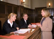 Glaser (Britta Schmeling, li.) und Lotze (Henry van Lyck, Mi.) hören den Ausführungen zu, die Barbara Stanek (Marthe Schwiers) bei der Verhandlung macht.