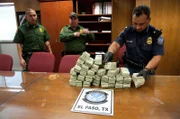 El Paso, TX: Officer Holguin and two agents counting a big pile of confiscated cash. Laundered money is one illegal item which is regularly smuggled across the border. This money would likely have been sent to a drug cartel.