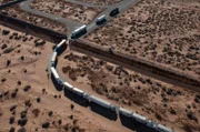 El Paso, TX: A line of trucks driving through the desert.