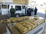 Pharr, Texas, USA: On a table sit bundles of marijuana that were hidden in a van, which is in the background.