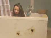 Gun shot holes in bathtub where young girl is hiding.
