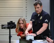Officer John Nolan (Nathan Fillion) steht vor einer kniffligen Aufgabe: Er soll die Fingerabdrücke einer jungen Frau (Marnee Carpenter) nehmen, die sich hartnäckig dagegen wehrt.