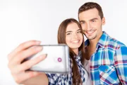 Closeup photo of a cheerful pretty couple in love making selfie