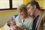 Erschöpft von der Geburt liegt Nikola (Mariele Millowitsch) in Schmidts (Walter Sittler) Armen, der sich liebevoll um sie kümmert.