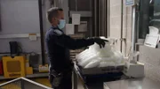 CBP-Beamter Irizar stapelt mehrere Pakete mit Methamphetamin, die im Fahrzeug eines Verdächtigen gefunden wurden, auf eine Waage, um sie zu wiegen (National Geographic).