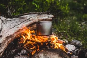 Kessel über dem Feuer hängend. Kochen von Essen am Feuer in der Wildnis.