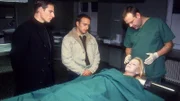 Der Polizeiarzt (Volker Weidlich, re.) erklärt Tom (René Steinke, li.), und Semir (Erdogan Atalay, Mi.), wie das Opfer Meike Moritz (Karina Kraushaar) zu Tode gekommen ist.